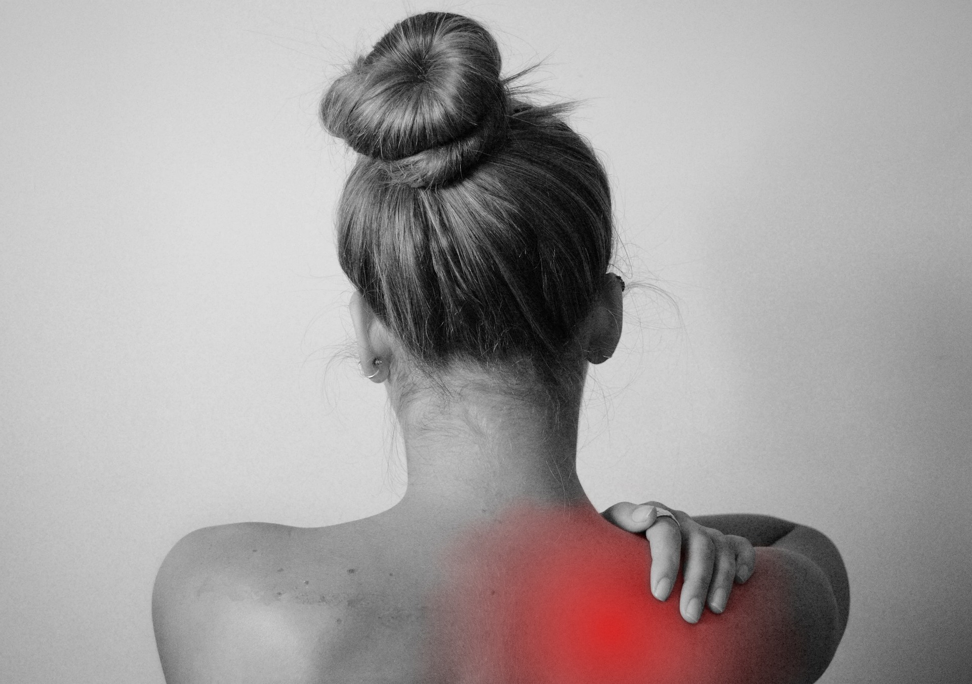 Femme de dos avec douleur en rouge sur l’homoplate
